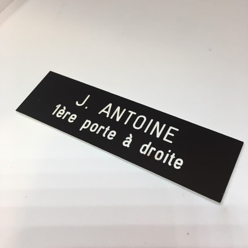 Plaque de boite aux lettres avec fond noir et texte gravé blanc
